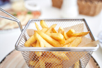 Basket with french fry. Potato chips. Cooking uhealthy lunch. Salty spicy junk. Oil takeaway gastronomy