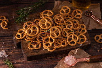 small salted pretzels with salt and spices on a wooden board