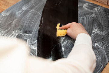 A young woman is cleaning an induction electric hob. Cleaning in the kitchen. Electric oven...