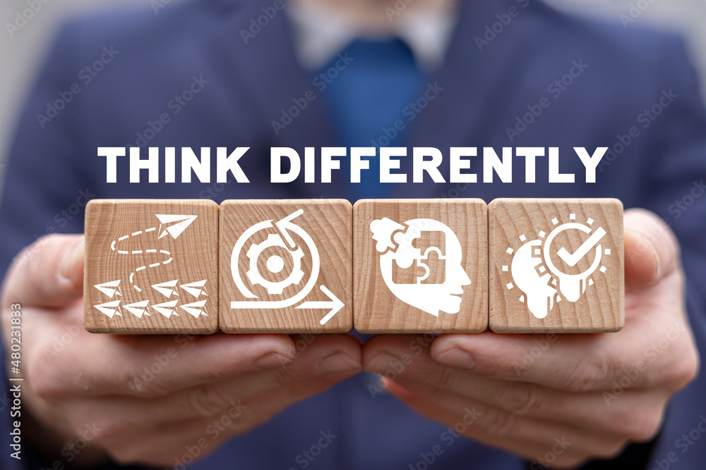 Poster think differently business concept. man holding wooden cubes with icons and think differently text. 