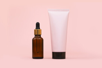 Mockup bottle of pink squeeze bottle plastic tube with black cap and brown glass bottle with...