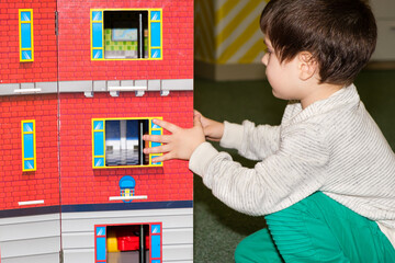 A 4-year-old boy plays in the playroom in the children's entertainment center with a toy big castle.