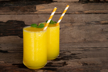 Mango juice fruit smoothies yogurt drink yellow healthy delicious taste in a glass slush for weight loss on wooden background.