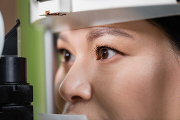 close up view of asian woman checking eyesight on blurred vision screener.