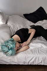 top view on sad caucasian female lying on bed, depressed upset woman at home alone, in dark bedroom, in the evening or morning. human emotions, depression, stress and crisis concept