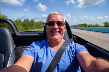 Handsome middle age man driving a convertible automobile