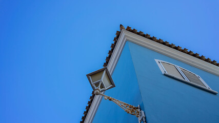 Fototapeta na wymiar Casa azul con farola y cielo azul