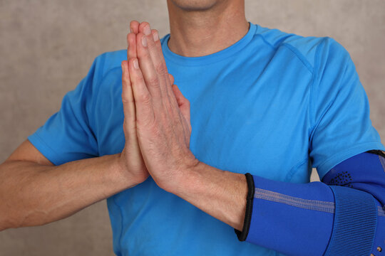 Man doing warming up exericeses : Elbow joint injury rehabilitation concept