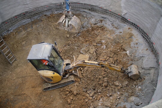 Kleiner Bagger baggert in einer Baugrube