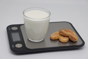 A glass of kefir on the scales. Weight loss, diet and weight control. Still life with healthy food...