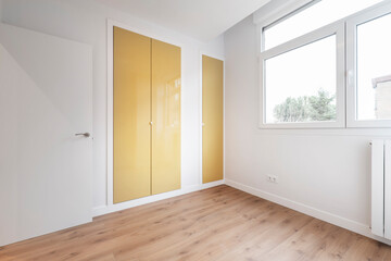 Bedroom with built-in wardrobe with mustard yellow lacquered doors