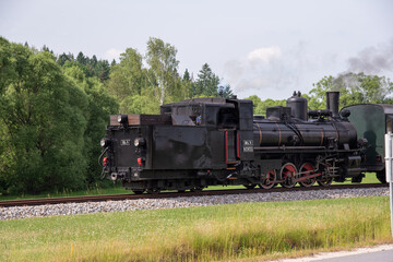 Fototapeta na wymiar On a summer day a steam engine in Lower Austria steams in reverse.