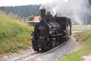 Fototapeta na wymiar On a summer day a steam engine in Lower Austria steams into town.