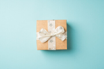 Top view photo of valentine's day decorations craft paper giftbox with white ribbon bow star pattern on isolated pastel blue background with copyspace