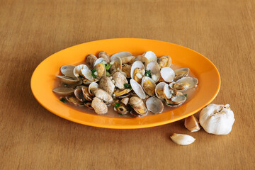 Chinese clams with black bean sauce and garlic on wooden table background