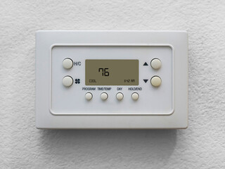 Digital home heating and air conditioning thermostat on wall