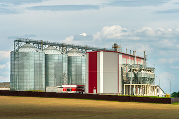 silver silos on agro manufacturing plant for processing drying cleaning and storage of agricultural...