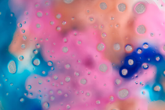 Soap foam on a colorful blurred background. Closeup.
