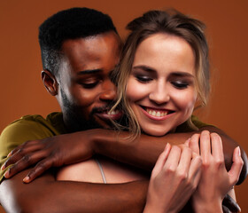 Young pretty couple diverse races together posing sensitive on brown background, lifestyle people...