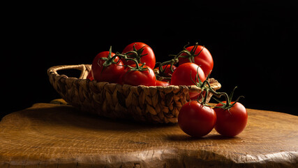 Fototapeta na wymiar Tomatoes, beautiful tomatoes in a straw basket, over rustic wood, selective focus.