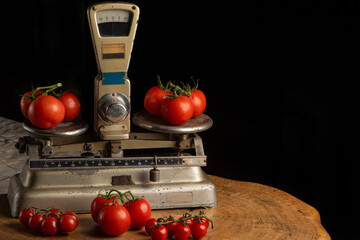 Tomatoes, beautiful tomatoes placed on an old weighing scale, over rustic wood, selective focus.