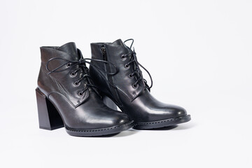 Women's boots with black genuine leather on heels isolated on a white background. photo from the side, diagonally and foreshortened from behind. Women's shoe collection 2022