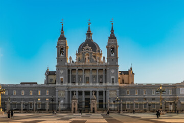 Madrid, Spain - November 30, 2021: Front view of the Almudena Cathedral from Plaza de la Armeria in Madrid. Facade of the residence of the Roman Catholic Archdiocese of Madrid in the Baroque style