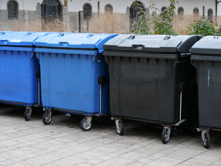 Eine Reihe von Müllcontainern für Papiermüll und Restmüll in einem Hof