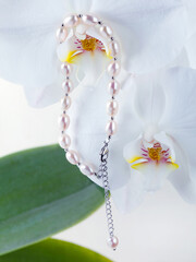 Obraz na płótnie Canvas Silver baroque pearl bracelet on orchid flower