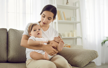 Loving young Caucasian mother sit on sofa play with baby infant enjoy maternity. Caring happy mom relax at home caress talk with newborn kid child. Good ivf treatment, fertility. Motherhood concept.