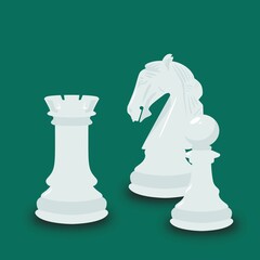 Three white chess pieces isolated on a green background.