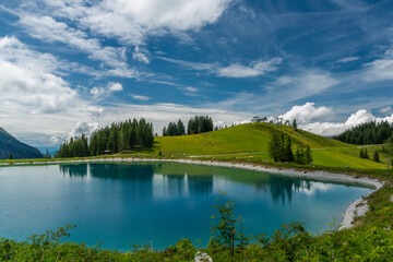 Fototapeta na wymiar Nice blue green lake on big mountains in Austria summer cloudy day