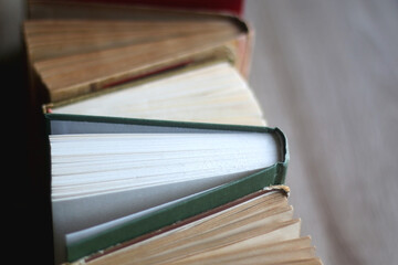 Bunch of vintage hardcover books on wooden background. Selective focus.