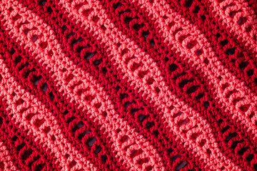 Knitted wave texture. Crocheted red pink wave pattern.
