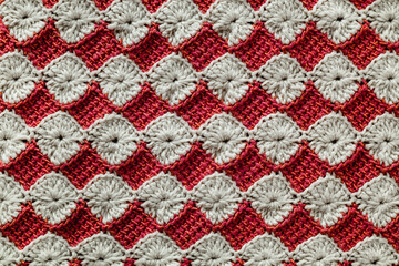 White and red crocheted floral pattern. Knitted texture.
