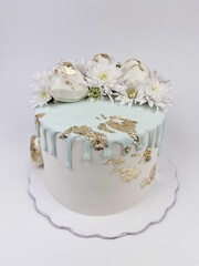 Pastel blanco con detalles en color oro y chocolate