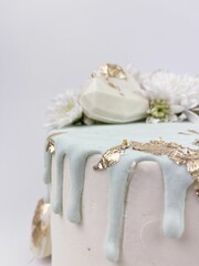Pastel blanco con detalles en color oro y chocolate