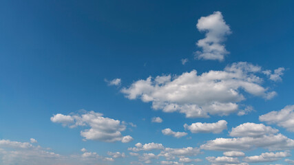 bright blue sky with group of white cumulus clouds as a natural background