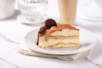 Piece of tiramisu cake on a white plate