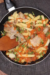 Vegetables stewed with chicken legs in a frying pan