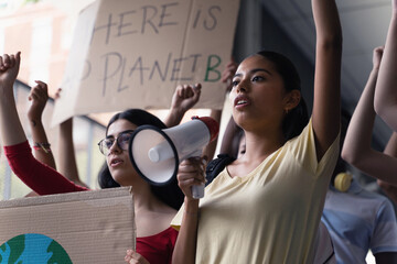 Female hispanic latin teenager students with placards and posters on global protest for climate change and Earth rights - obrazy, fototapety, plakaty