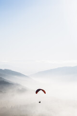 Red parachute in the sky above the mountains 