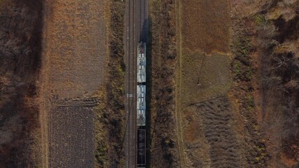 View of train from above. Locomotive pulls railway freight train with wagons filled coal. Aerial Drone View. Logistics, delivery cargo. Rail travel, Railroad trips. Rail transportation, railage
