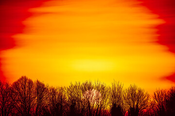 Fototapeta na wymiar a powerful intense sunrise fills the horizon with a fiery blanket of red, orange and yellow, Wiltshire UK