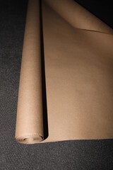 Roll of old ocher craft paper on the dark background