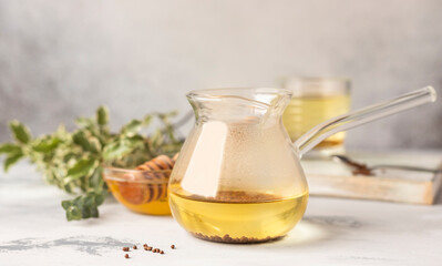 Buckwheat tea and granules with honey, light grey background. Healthy buckwheat tea, Ku Qiao seeds....