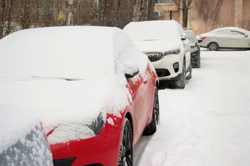 cars strewn with snow are parked in the parking lot