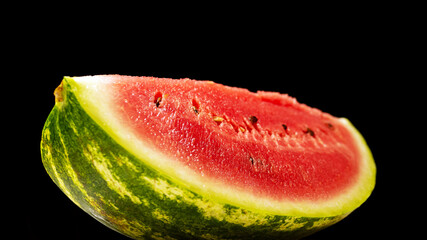 Fresh watermelon slice on black background, natural juicy watermelon closeup
