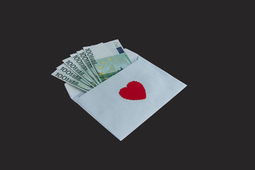 Paper envelope with 100 euro banknotes and a red heart on a black background. Banknotes stick out from the envelope. Conceptual gift for Valentine's Day, wedding, birthday.