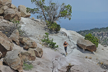 Woman jogging on trail in hills, Santa Fe, New Mexico, USA